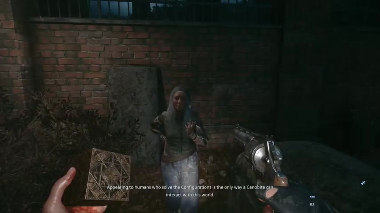 Eine Frau in der Nähe einer Mauer spricht mit dem Helden, in seiner Hand hält er eine Konfigurationsbox in Hellraiser: Revival